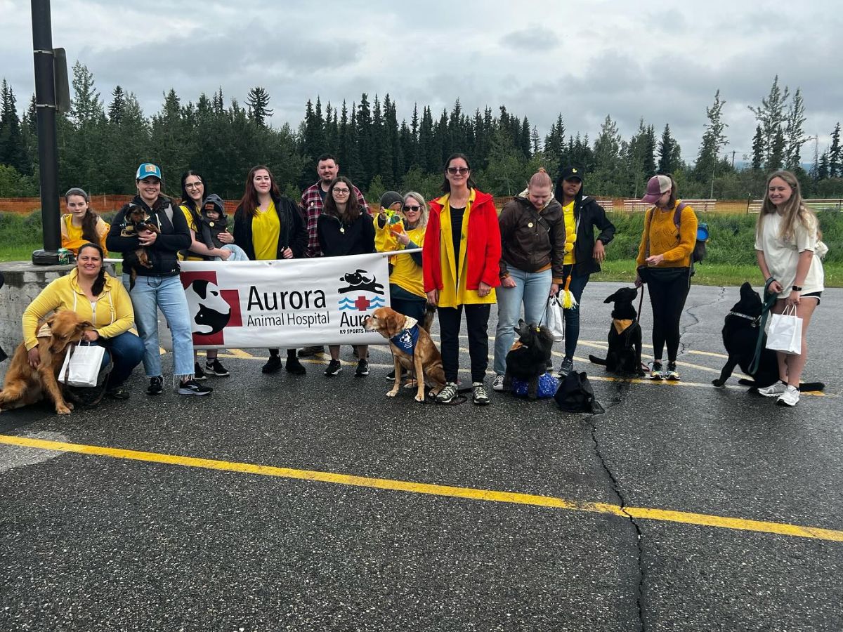 Aurora Animal Hospital team holding poster of hospital sign